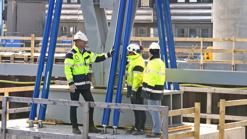 Peo Halvarsson står med två kollegor på projektet Hisingsbron med skyddskläder och kollar på konstruktionen.