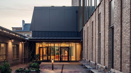 The facade is inspired by the existing buildings in the immediate area and consists of brick, bronze-colored panels and glass. Photographer: Felix Gerlach 