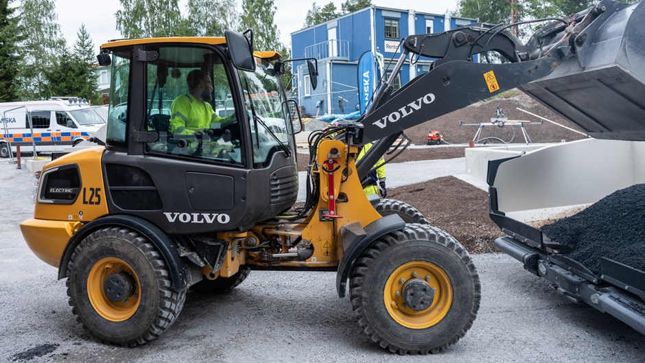 Liten, eldriven hjullastare från Volvo kör med höjd skopa.