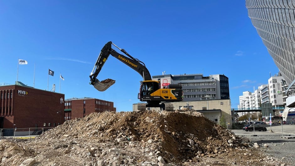 Elektrisk grävmaskin som lastar på schaktbil.