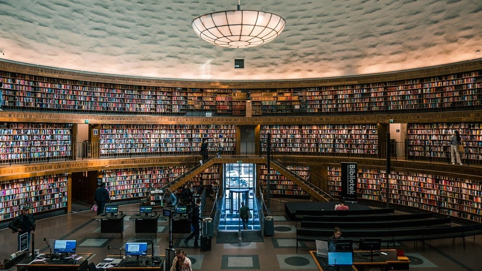 Stadsbilbioteket interiör rund vägg med böcker och besökar Foto Alexandre van  Thuan Unsplash